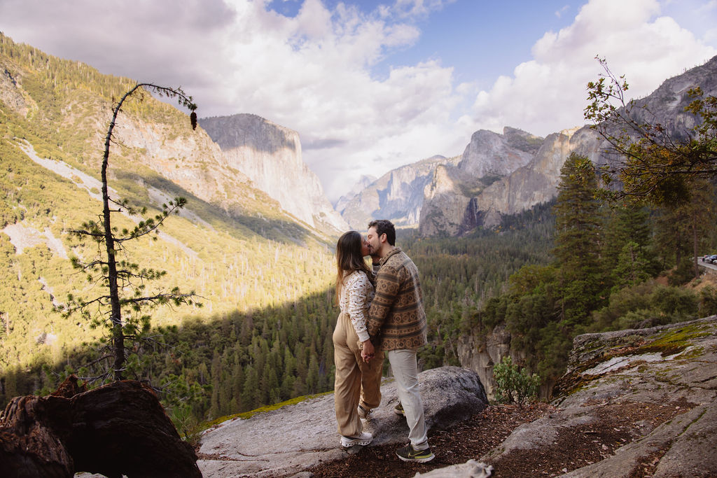 a couple takes photos at tunnel view after a proposal at yosemite national park