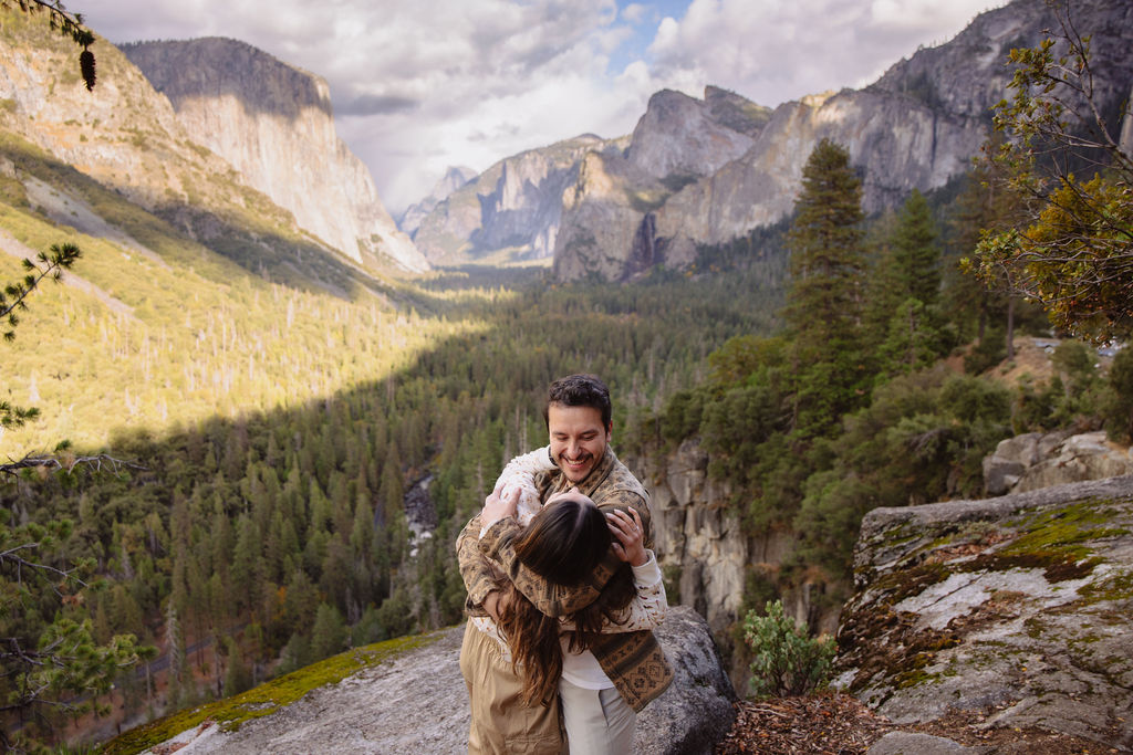 a couple takes photos at tunnel view after a proposal at yosemite national park