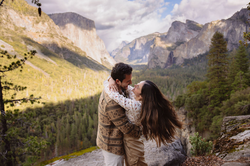 a couple takes photos at tunnel view after a proposal at yosemite national park