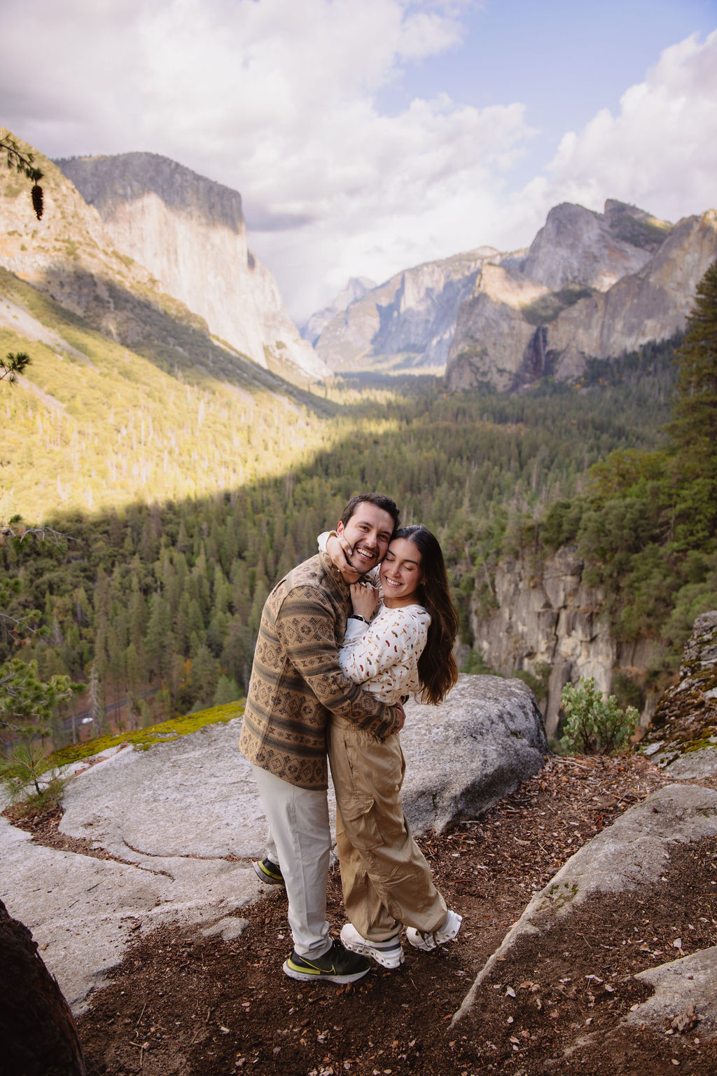 a couple takes photos at tunnel view after a proposal at yosemite national park