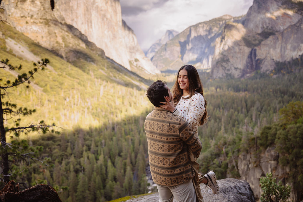 a couple takes photos at tunnel view after a proposal at yosemite national park