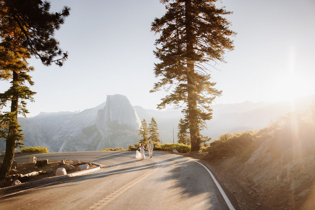 couple running through the road at in yosemite for eloping in a national park