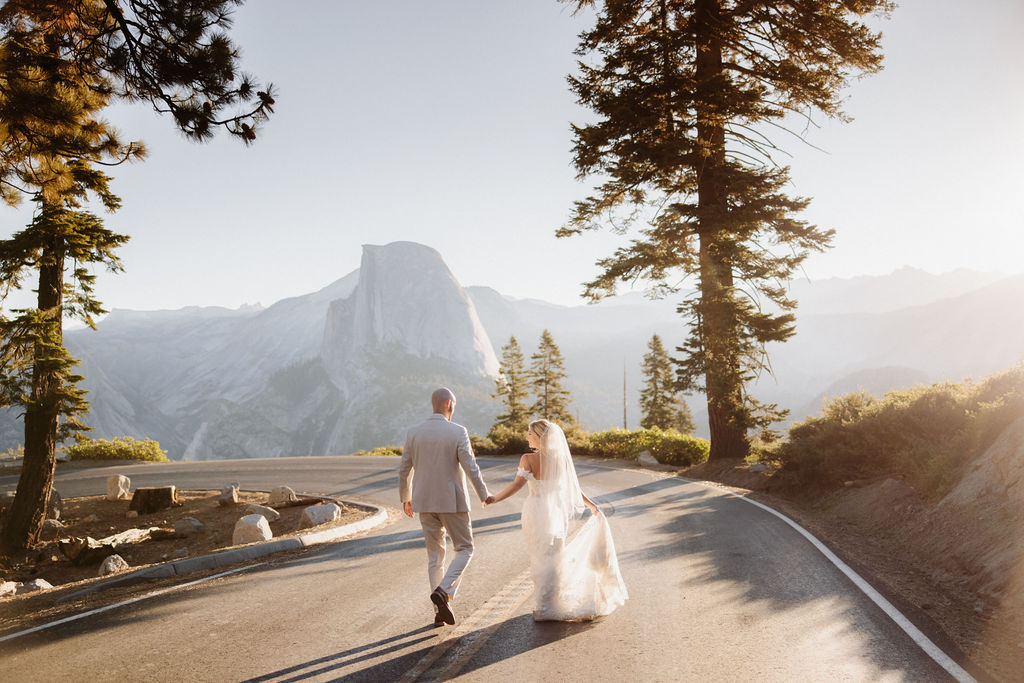 couple running through the road at in yosemite for eloping in a national park