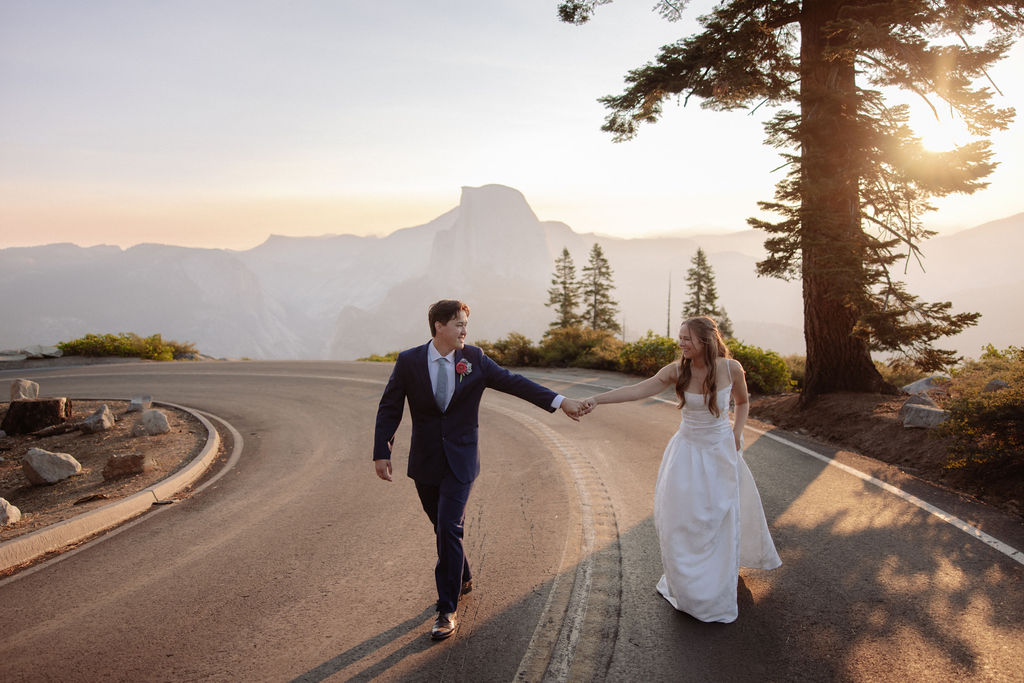 A man and woman holding hands on a road.