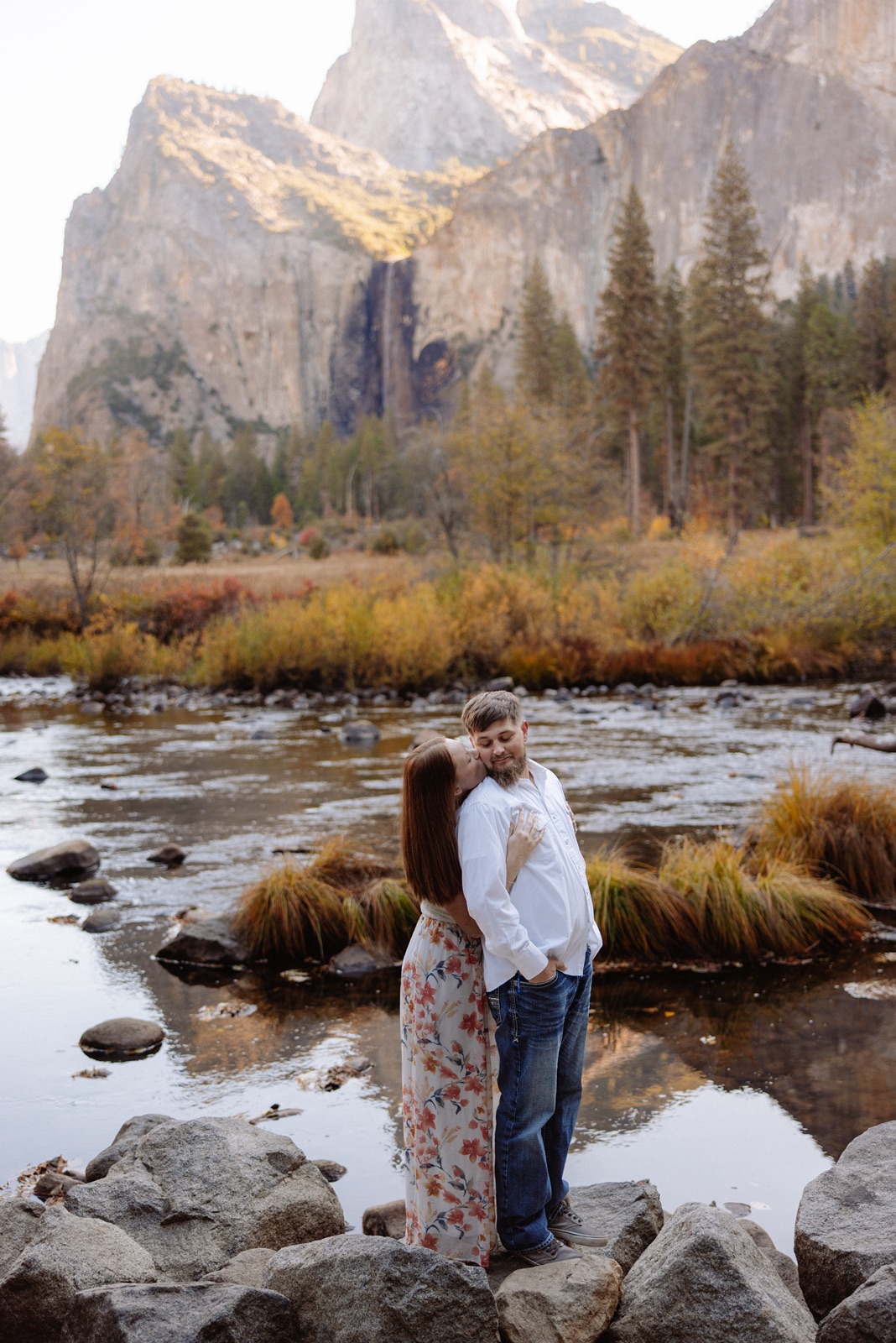 Woman wraps arms around man during fall Yosemite engagement photos