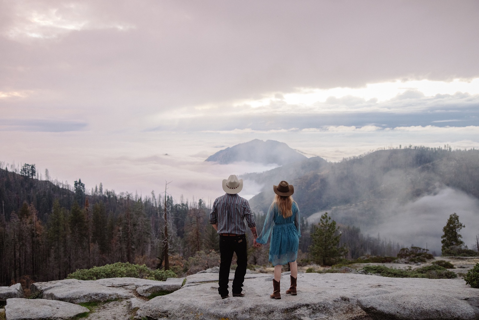 Man and woman in cowboy hats look out into Sequoia National Park