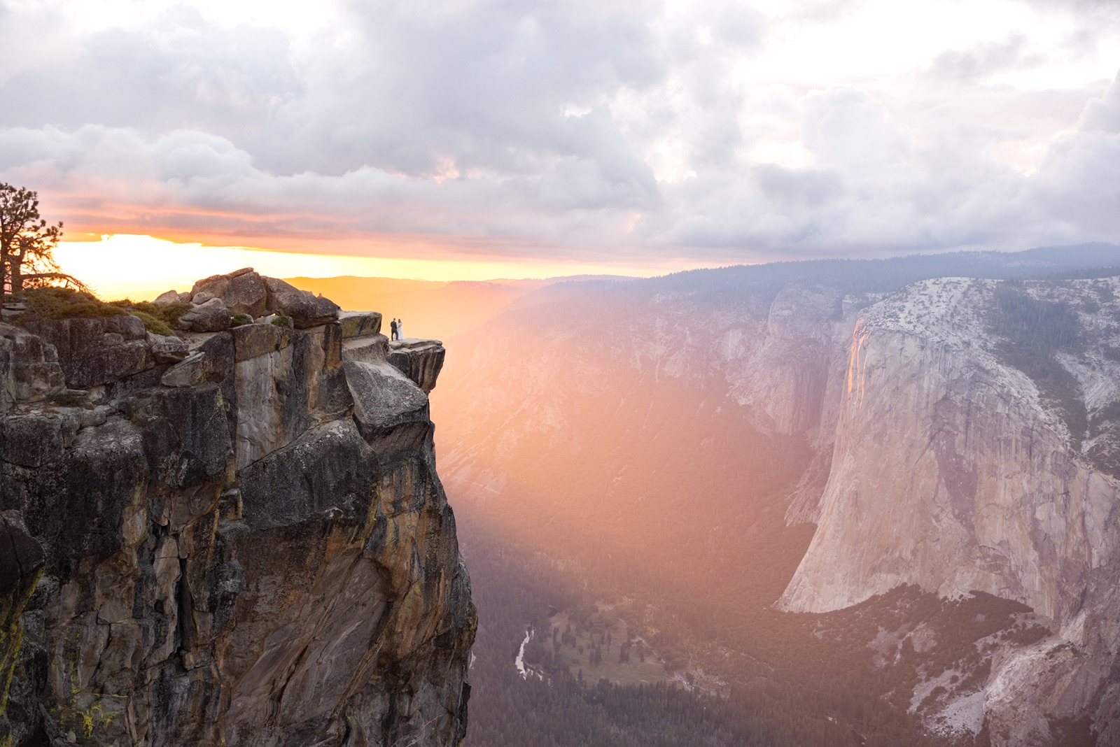 Couple on a ledge at Taft Point during sunset