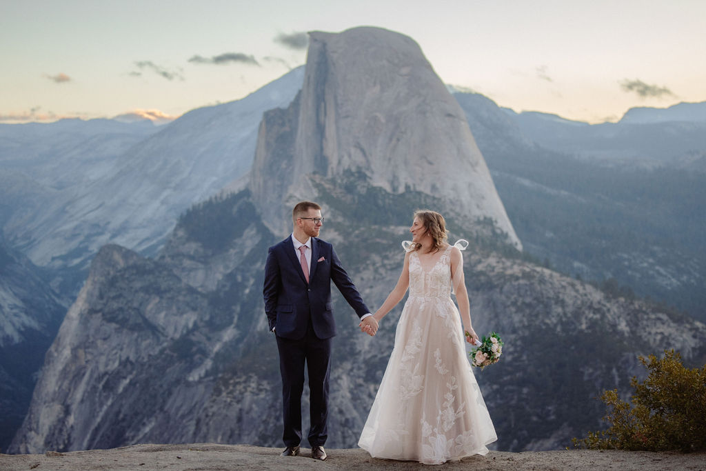 Bride and groom holding hands at cloudy Yosemite elopement