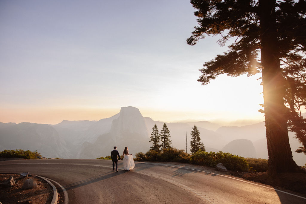 Bride and groom hold hands in Yosemite at sunset