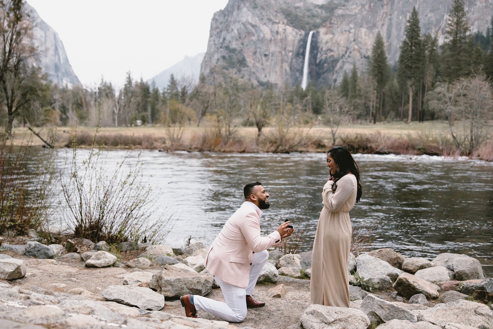 Man on one knee proposing at Valley View in Yosemite