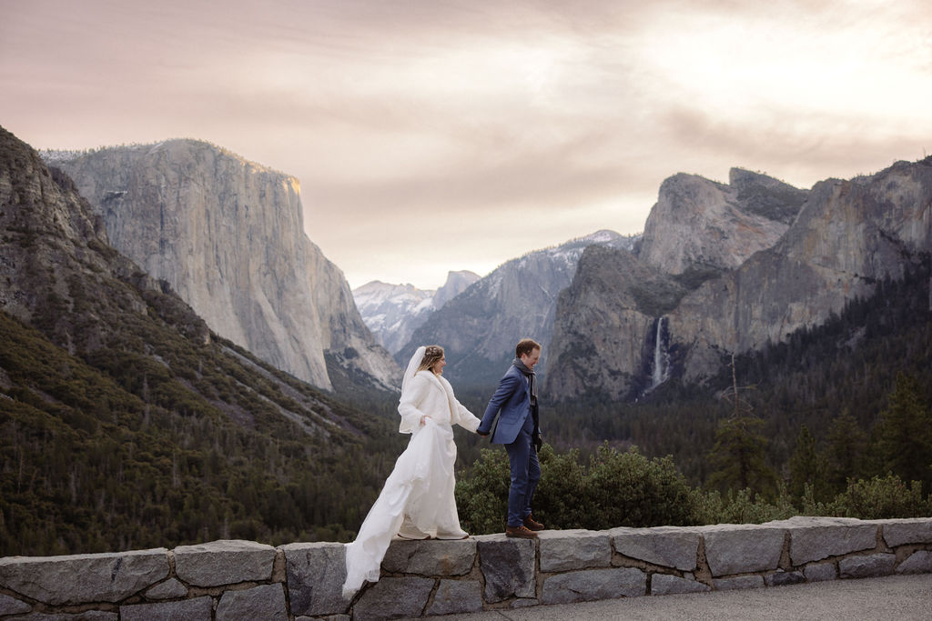 Bride and groom holding hands at Tunnel View in Yosemite