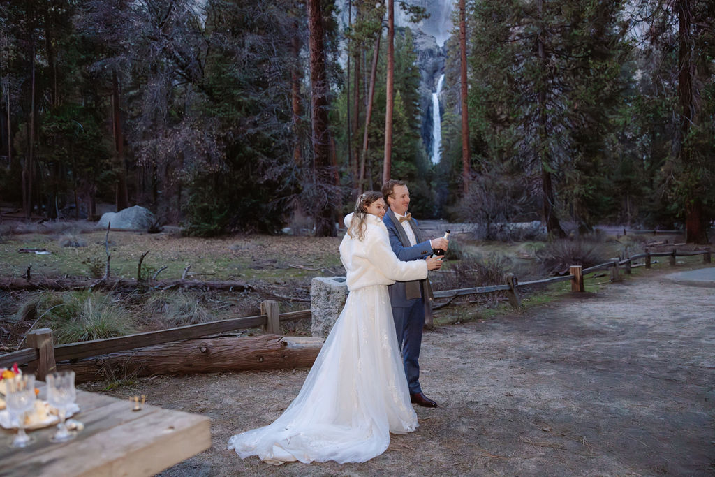 Bride and groom pop champagne at their Yosemite hiking elopement