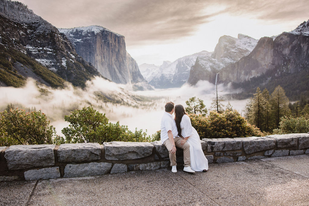 Couple takes in the views during cloudy spring Yosemite engagement session