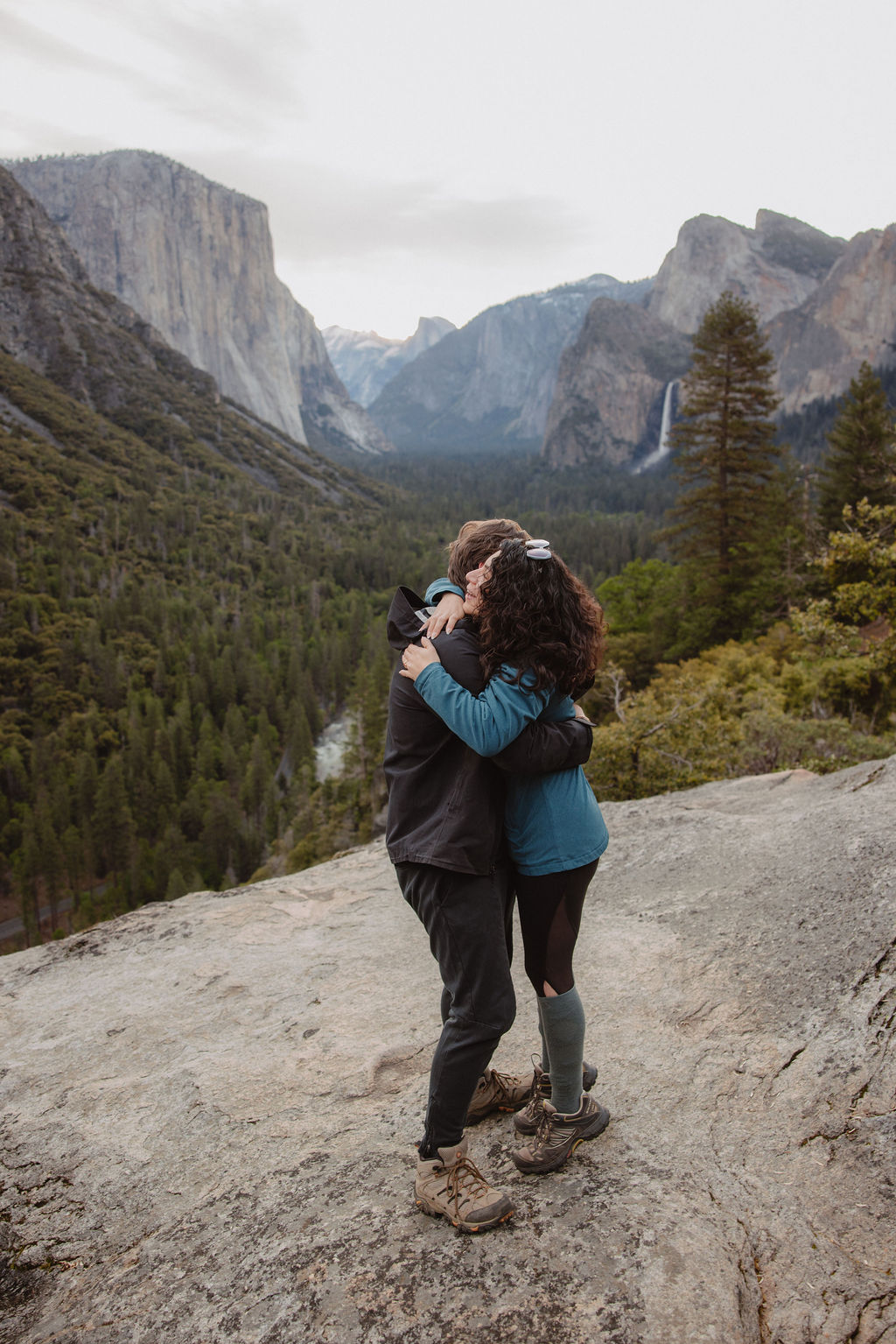 Couple hugs during proposal photos in Yosemite