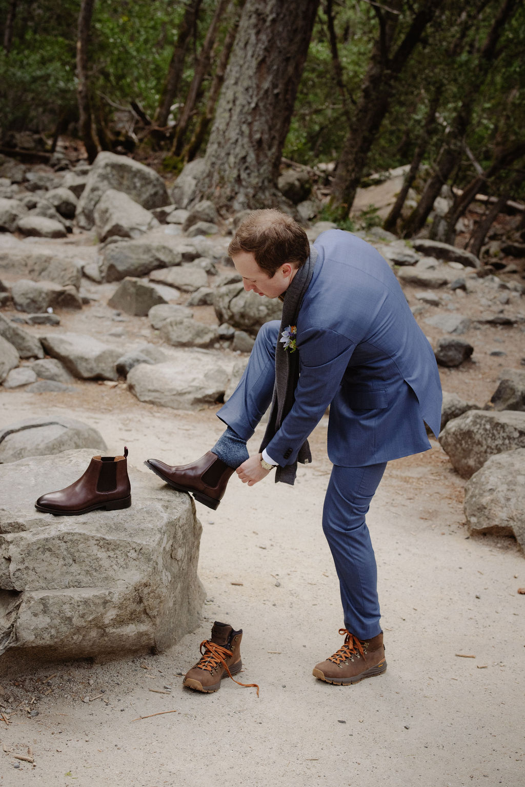 Groom changing elopement shoes mid-day