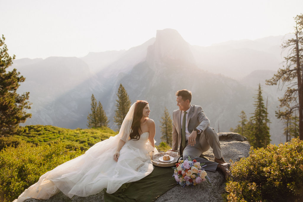 Bride and groom cut cake before their sunrise Glacier Point elopement