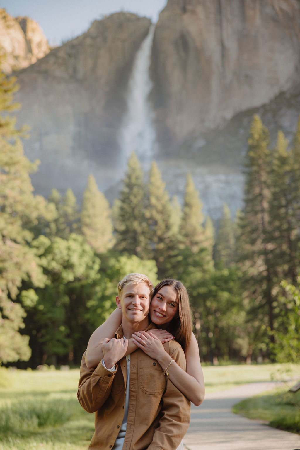 Woman hugs man at their dreamy surprise proposal in Yosemite